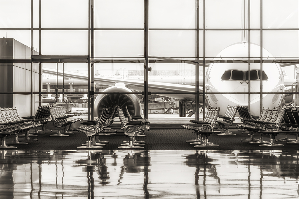 Awaiting Departure: A serene view of the terminal at Washington Dulles Airport, with rows of empty seats reflecting on the polished floor, and the next flight awaits just beyond the glass. Washington Dulles Airport, USA