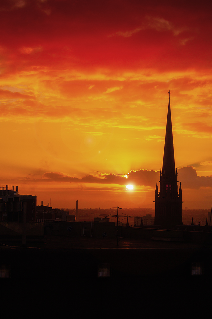 Sunrise in Melbourne; bathed in the golden hues of sunrise, with the silhouette of St. Patrick's Cathedral's spire standing tall against the vibrant morning sky.