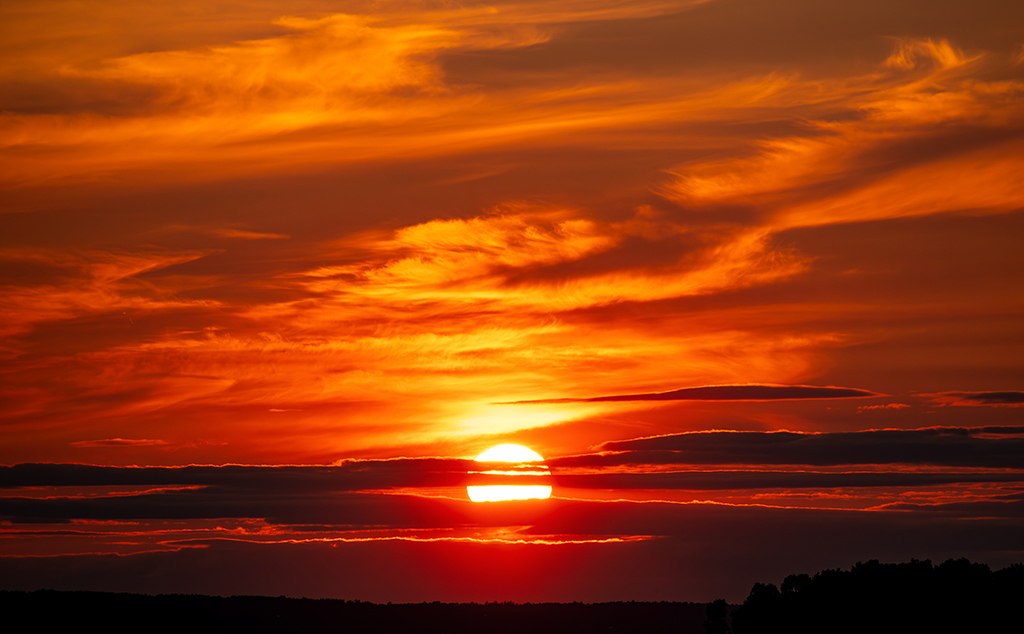 A breathtaking sunset where fiery hues dance across the sky, painting a mesmerizing farewell to the day. Britannia, Ottawa, Ontario